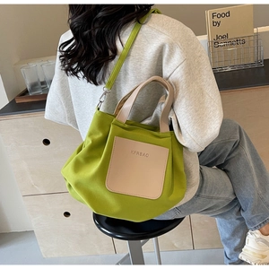 Détail du cabas en nylon vert avec poche en cuir beige et bandoulière réglable pratique