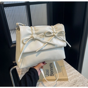 Détail du sac à bandoulière plissé blanc crème avec nœuds décoratifs et similicuir premium