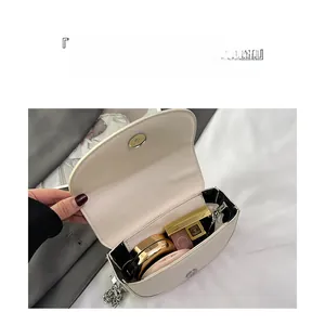 Detailed interior of mini cream saddle bag showing storage for makeup and accessories