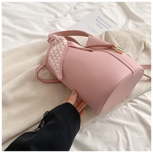 Close-up of pink bucket bag with litchi grain leather and checkered silk scarf