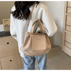 Vue arrière d'un mannequin portant le sac fourre-tout beige en nylon avec poche frontale