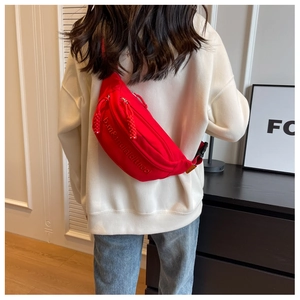 Detail of red nylon waist bag with embossed letters and double zipper on male model back