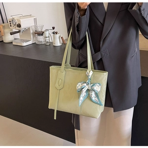 Detailed close-up of sage green PU leather tote bag with a decorative fashion silk scarf