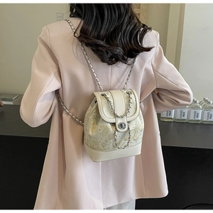 Detailed view of cream mini backpack with gold butterfly print and chain strap