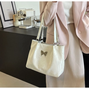 Detail of cream white butterfly tote bag with silver metallic hardware and fine texture