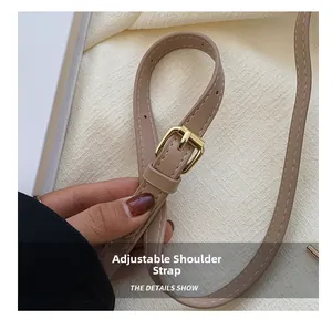 Détail de la bandoulière réglable en cuir avec boucle en métal doré sur le sac matelassé