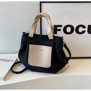 Détail du sac cabas en nylon noir avec poignées en cuir beige et poche KFRBAO