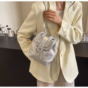 Detail of silver butterfly print mini backpack with metal chain and turn-lock closure