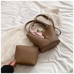 Detail of brown litchi leather bucket bag with pink printed silk scarf handle