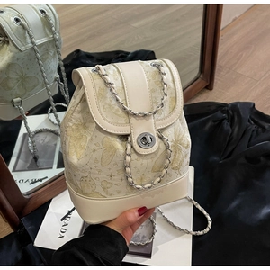 Detail of cream PU mini backpack with golden butterfly embroidery and chain straps