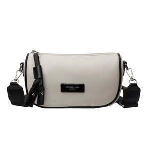 Chic beige cylindrical crossbody bag with contrasting black wide strap and silver zipper