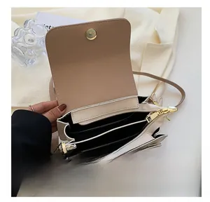 Vue intérieure d'un petit sac beige matelassé avec poches multiples et fermoir magnétique