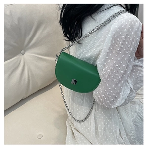 Detail of a bright green semi-circle saddle bag with silver chain and metal buckle