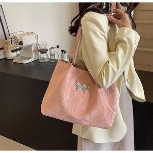 Close-up of pink wrinkled texture tote bag with silver mirror butterfly metal ornament