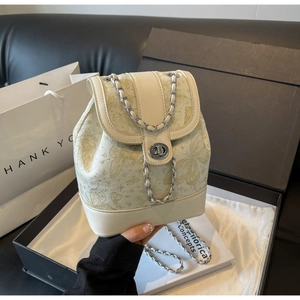 Detailed shot of cream butterfly jacquard backpack with silver chain in elegant gift box