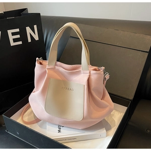 Détail du déballage d'un sac cabas plissé en nylon rose avec poche en cuir en boîte