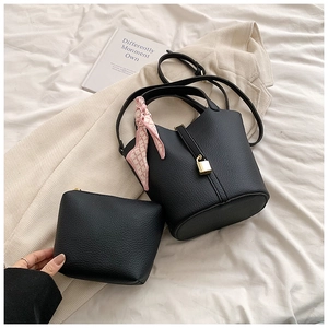 Close-up of black pebble leather bucket bag with silk scarf and matching inner pouch