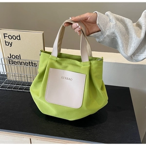 Détail du sac fourre-tout en nylon vert clair avec poche crème et anneaux en métal