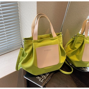 Détail du sac cabas en nylon vert avec poche en cuir crème et bandoulière amovible
