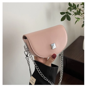 Detailed view of pink semi-circular saddle bag with silver chain strap and metal stud
