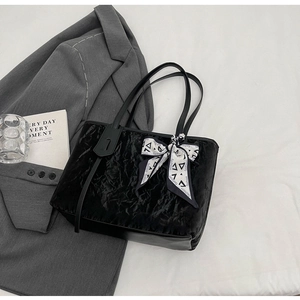 Detail of black textured tote bag with velvet wrinkles and fashion geometric silk scarf