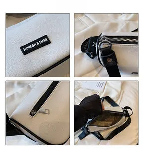 Detail view of white lychee grain texture bag with black strap and silver metal zipper
