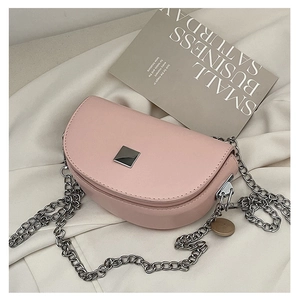 Detailed view of pink saddle bag with silver chain strap and square metal buckle