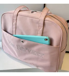 Detail der rosa Reisetasche mit Fronttasche und darin verstautem blauem Tablet-Gerät