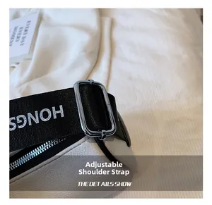 Detail of adjustable woven shoulder strap with letter print and silver metal buckle