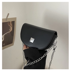 Detail of black matte saddle bag with silver hardware and chunky chain strap