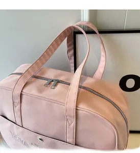 Detailansicht der rosa Reisetasche mit strapazierfähigem Stoff und Markenstickerei