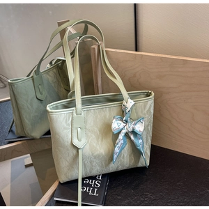 Detail of sage green tote bag with crinkled texture and decorative fashion silk scarf
