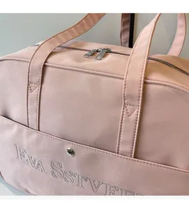 Nahaufnahme der rosa Reisetasche mit Stickerei, Stoffstruktur und robustem Reißverschluss