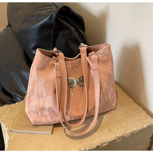 Detailed view of pink tote bag with pleated texture and silver butterfly metal buckle
