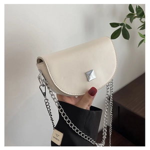Detail of off-white leather saddle bag with silver chain strap and square buckle decoration
