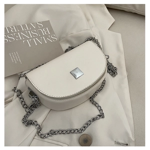 Detailed top view of a cream mini saddle bag with silver chain strap and metal buckle
