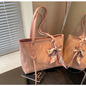 Detailed view of pink tote bag featuring artistic pleated texture and fashion silk scarf