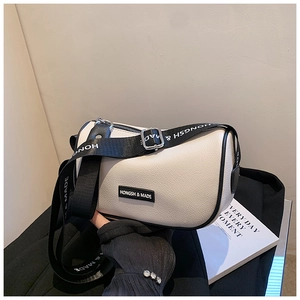 Detail of white PU leather crossbody bag with black trim and branded nylon wide strap