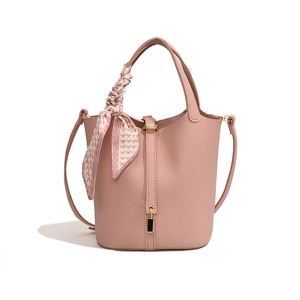 Pink pebbled leather bucket bag with decorative silk scarf handle and metal clasp closure