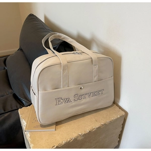 Detailansicht der cremefarbenen Reisetasche aus PU-Leder mit großer Tasche und Magnetverschluss