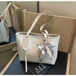 Detail of cream tote bag with pleated texture and fashion printed silk scarf bow
