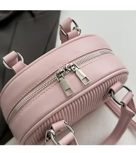 Dettaglio della borsa bowling rosa a pieghe con doppia cerniera argentata e texture