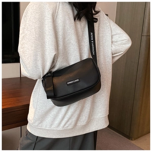 Side view of black leather crossbody bag with HONGSH & MADE branding on wide strap