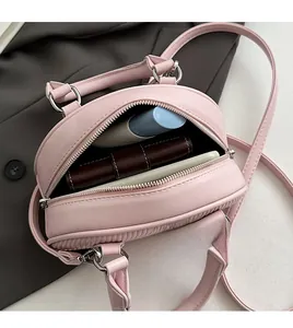 Dettaglio interno borsa trapuntata rosa con spazio per rossetto e portafoglio