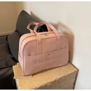 Detailansicht der rosa Canvas-Reisetasche mit Stickerei und großer Fronttasche