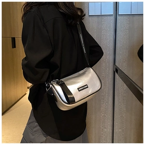 Side view of metallic silver crossbody bag with HONGSH & MADE branding and black strap
