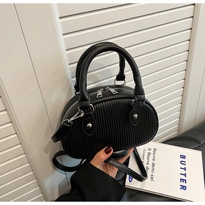 Dettaglio della mini borsa boston nera con trama a pieghe e hardware argentato