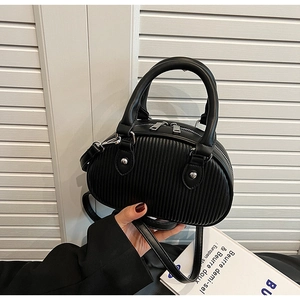 Dettaglio borsa a tracolla nera a pieghe con doppie cerniere argentate e texture