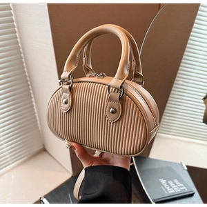 Dettaglio della borsa a mano plissettata beige con doppie cerniere e manici robusti