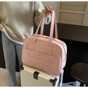 Nahaufnahme der rosa Reisetasche mit Schriftzug auf weiß gestreiftem Koffer im Zimmer